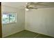 Comfortable bedroom with a ceiling fan, a window providing natural light, and carpeted floor at 5050 Prosch Cir, North Port, FL 34288