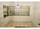 Cozy dining area with tiled floor, two windows with blinds, and a decorative light fixture at 5050 Prosch Cir, North Port, FL 34288