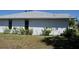 Side exterior view of the home with new siding, featuring flowering bushes at 5050 Prosch Cir, North Port, FL 34288