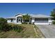Charming single Gathering home with a two car garage, mature landscaping, and blue accents at 5050 Prosch Cir, North Port, FL 34288