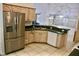 Kitchen with stainless steel refrigerator, tile floor, and abundant counter space at 5050 Prosch Cir, North Port, FL 34288