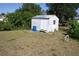 Outdoor storage shed with blue barrel in an overgrown backyard provides extra space at 5050 Prosch Cir, North Port, FL 34288