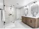 Bright bathroom featuring a glass enclosed shower, a double sink vanity, and patterned tile flooring at 8115 Manasota Key Rd, Englewood, FL 34223
