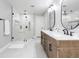 Bright bathroom featuring a glass enclosed shower, a double sink vanity, and patterned tile flooring at 8115 Manasota Key Rd, Englewood, FL 34223