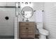 Bathroom features walk-in shower, round mirror, wood vanity, and white subway tile at 8115 Manasota Key Rd, Englewood, FL 34223