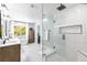 Bright bathroom featuring a glass enclosed shower, soaking tub, a double sink vanity, and patterned tile flooring at 8115 Manasota Key Rd, Englewood, FL 34223