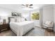 Primary bedroom with a large window, king bed, hardwood floors, and cozy seating area at 8115 Manasota Key Rd, Englewood, FL 34223