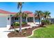 Inviting home featuring a covered entrance, colorful landscaping, and a well-maintained lawn, exuding charm and curb appeal at 8115 Manasota Key Rd, Englewood, FL 34223