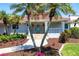 Beautiful home showcasing a covered entrance with elegant landscaping and lush greenery, enhancing its welcoming facade at 8115 Manasota Key Rd, Englewood, FL 34223