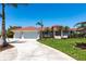 Charming home with a well-manicured lawn, a spacious three-car garage, and lovely landscaping, creating a welcoming curb appeal at 8115 Manasota Key Rd, Englewood, FL 34223