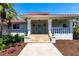Charming single-story home featuring a red tile roof, elegant columns, and a lush, well-maintained landscaped yard at 8115 Manasota Key Rd, Englewood, FL 34223