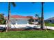 Attractive home with a manicured lawn and a three-car garage, complemented by swaying palm trees, creating a serene tropical vibe at 8115 Manasota Key Rd, Englewood, FL 34223