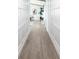 Bright hallway featuring white walls with stylish wainscoting and modern wood-look floors at 8115 Manasota Key Rd, Englewood, FL 34223