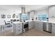 Modern kitchen with stainless steel appliances, light gray cabinetry, and a dining area with waterfront views at 8115 Manasota Key Rd, Englewood, FL 34223