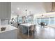 Open-concept kitchen featuring a central island, stainless appliances, and a dining area overlooking the water at 8115 Manasota Key Rd, Englewood, FL 34223