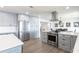 Modern kitchen with stainless steel appliances, a center island, and open access to the dining area at 8115 Manasota Key Rd, Englewood, FL 34223