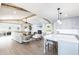 Open-concept living room with a kitchen, beamed ceilings, a fireplace, and plenty of natural light at 8115 Manasota Key Rd, Englewood, FL 34223