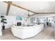 Open-concept living room features exposed wooden beams, a fireplace, and a seamless flow into the kitchen area at 8115 Manasota Key Rd, Englewood, FL 34223