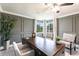 Home office featuring a dark wood desk, crown molding, and plush seating with bright natural light at 8115 Manasota Key Rd, Englewood, FL 34223