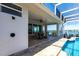 Covered patio with outdoor dining near a pool and tranquil waterfront view at 8115 Manasota Key Rd, Englewood, FL 34223