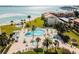 Aerial view showcasing a large community pool, beach access, and well-maintained landscaping for an exceptional waterfront lifestyle at 851 Bayway Blvd # 403, Clearwater Beach, FL 33767