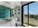 Cozy bathroom with sliding doors to balcony, views of the water, decorative wallpaper and granite countertops at 851 Bayway Blvd # 403, Clearwater Beach, FL 33767