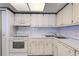 Clean kitchen featuring white appliances, cabinetry, and a double sink for modern living at 851 Bayway Blvd # 403, Clearwater Beach, FL 33767