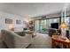 Comfortable living room featuring neutral walls, carpeting, and a sliding glass door to a balcony at 851 Bayway Blvd # 403, Clearwater Beach, FL 33767