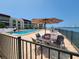 Waterfront condo boasts a luxurious pool and patio area with lounge seating and gorgeous water views for ultimate relaxation at 851 Bayway Blvd # 403, Clearwater Beach, FL 33767