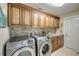 Spacious laundry room with modern machines, tiled backsplash, and wooden cabinets at 925 Don Juan Ct, Punta Gorda, FL 33950