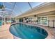 The screened-in pool is surrounded by a brick patio, with access to the home's interior through sliding glass doors at 925 Don Juan Ct, Punta Gorda, FL 33950