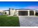 Stunning modern home boasts clean lines, a metal roof, a spacious driveway, and a manicured front lawn at 10522 Riverside Rd, Port Charlotte, FL 33981
