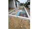 Unfinished in-ground pool with tile accents, set in a spacious backyard with dirt landscaping at 10522 Riverside Rd, Port Charlotte, FL 33981