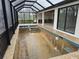 The unfinished pool is surrounded by a black screen enclosure and paver coping at 10522 Riverside Rd, Port Charlotte, FL 33981
