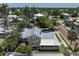 An aerial shot of a two-story home surrounded by lush palm trees and greenery in a residential area at 110 Gilchrist St, Punta Gorda, FL 33950