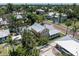 Aerial view of a yellow house with white trim and a metal roof surrounded by palm trees and lush greenery at 110 Gilchrist St, Punta Gorda, FL 33950