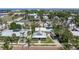 Aerial view of a home with a porch, surrounded by palm trees and other well-kept houses on a sunny day at 110 Gilchrist St, Punta Gorda, FL 33950