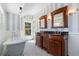 Elegant bathroom with black and white tile flooring, striped wallpaper, clawfoot tub, and double vanity at 110 Gilchrist St, Punta Gorda, FL 33950