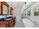 Bright bathroom with a standalone bathtub, blue-striped walls, and a double vanity at 110 Gilchrist St, Punta Gorda, FL 33950