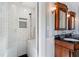 Walk-in shower featuring subway tile and a built-in seat; dual vanity and sconce in the background at 110 Gilchrist St, Punta Gorda, FL 33950