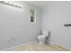 Bathroom featuring light gray walls, wood-look tile floors, and a white toilet at 110 Gilchrist St, Punta Gorda, FL 33950