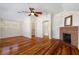 Bright bedroom featuring wood floors, ceiling fan, closet, and a decorative brick fireplace at 110 Gilchrist St, Punta Gorda, FL 33950
