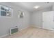 Bedroom featuring wood-look tile floors, light gray walls, and a white door on the right at 110 Gilchrist St, Punta Gorda, FL 33950
