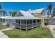 Charming two-story home featuring a wraparound porch, a metal roof, and a well-manicured lawn at 110 Gilchrist St, Punta Gorda, FL 33950