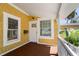 Charming covered front porch with wood flooring and yellow shingle siding details at 110 Gilchrist St, Punta Gorda, FL 33950