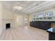 An open concept kitchen boasting black lower cabinets, a fireplace, and views of the living area at 110 Gilchrist St, Punta Gorda, FL 33950