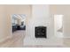 Bright living room showcasing a white brick fireplace, light floors and leading to kitchen and stairway at 110 Gilchrist St, Punta Gorda, FL 33950