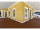A covered porch and entryway with a beautiful wood floor and decorative white trim at 110 Gilchrist St, Punta Gorda, FL 33950