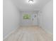 Room featuring wood-look tile floors, light gray walls, a window, and a white door at 110 Gilchrist St, Punta Gorda, FL 33950