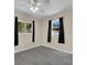 Well-lit bedroom with hardwood-style floors, two windows, and a ceiling fan at 1210 Marlow St, Port Charlotte, FL 33952